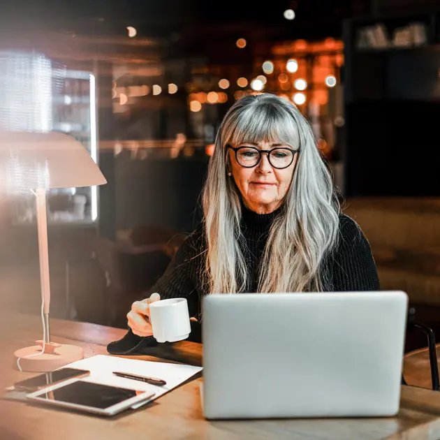 Gråhårig kvinna med dator.
